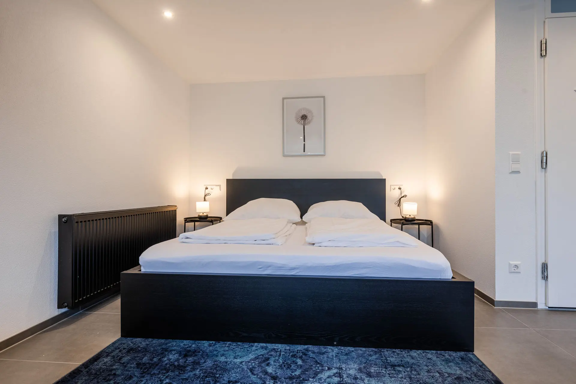 Großes Doppelbett mit Nachttischen und Leselampen