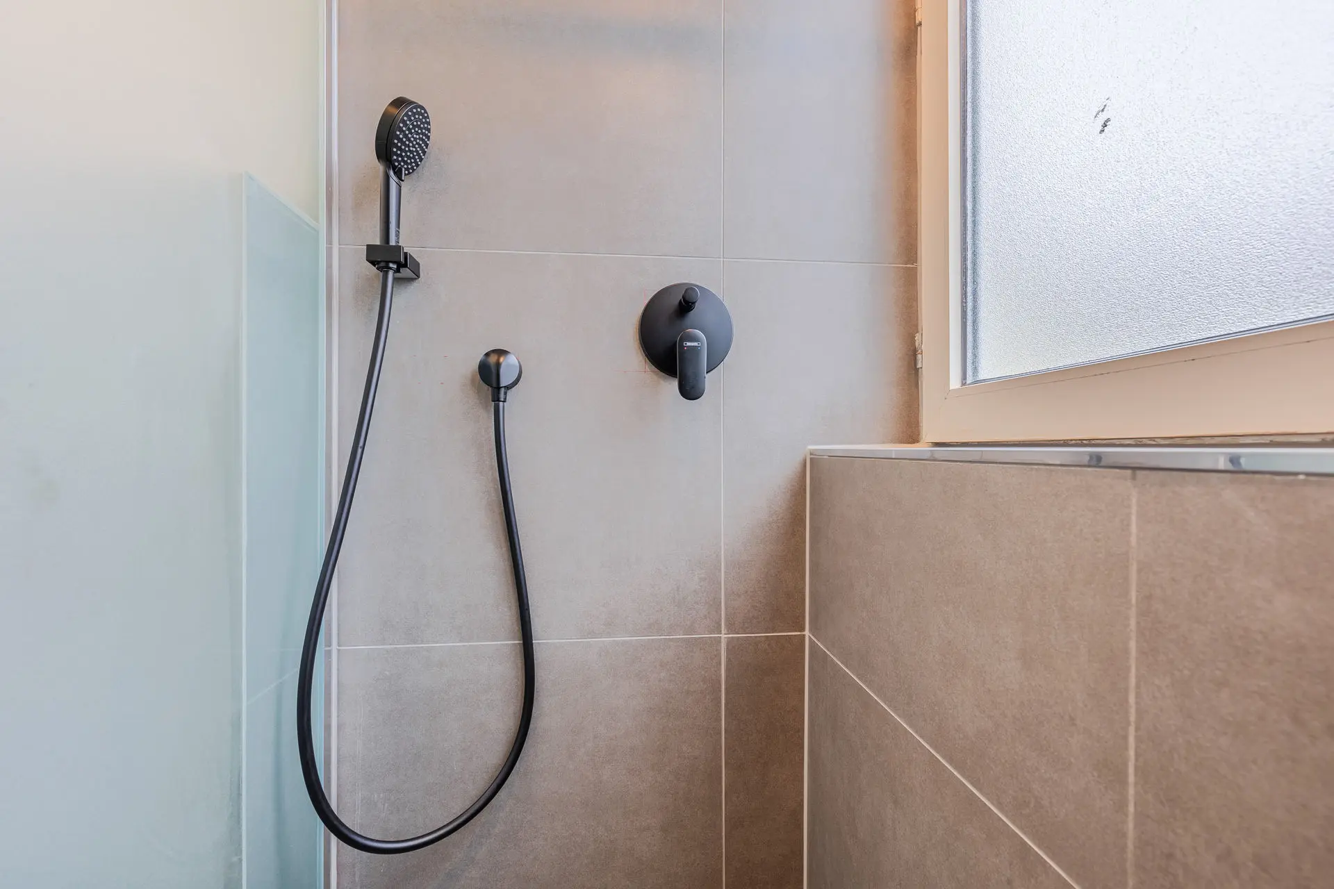 Geräumige Dusche mit schwarzer Armatur